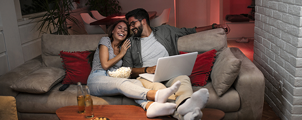 Cosy couple on the couch at home watching tv